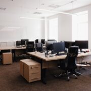 Intérieur d'un espace de travail moderne, avec bureaux, chaises et ordinateurs.